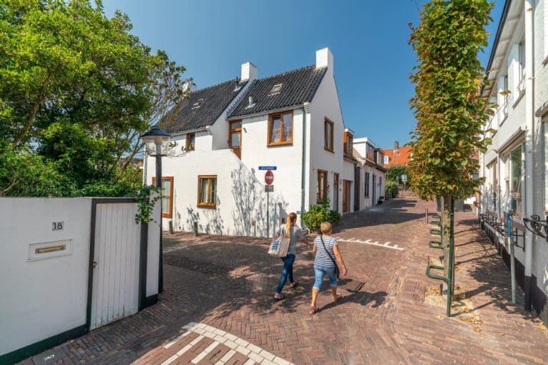 Twee vrouwen wandelen in de zomer in het weekend door de Sloppies in het dorp van Zandvoort.