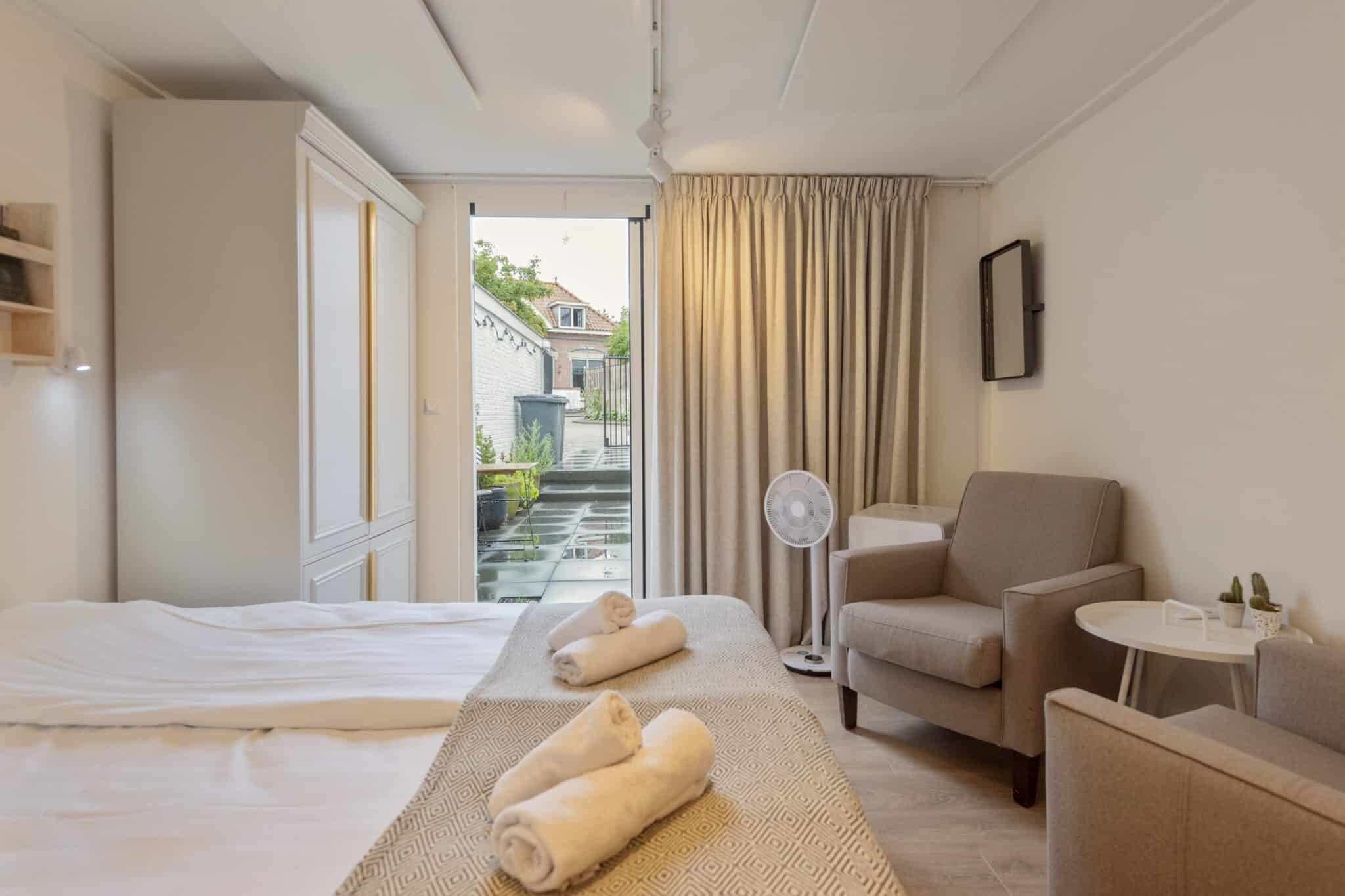 Slaapruimte en uitzicht op patio van accommodatie De oude Drukkerij in het centrum van Zandvoort
